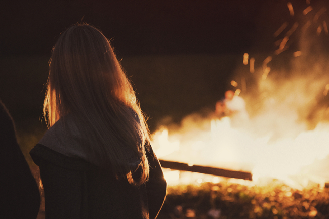 Girl looking into bonfire